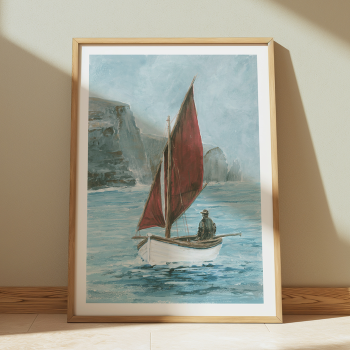 Framed artwork of a sailboat with a red sail on sea.