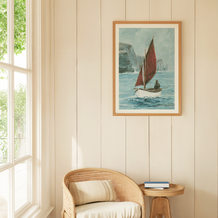 Framed artwork of a sailboat on a wall above a wicker chair with a window to the left.