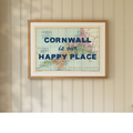 Framed map print of Cornwall with 'Cornwall is our happy place' text on a wall.