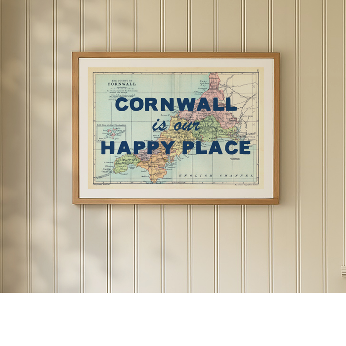 Framed map print of Cornwall with 'Cornwall is our happy place' text on a wall.