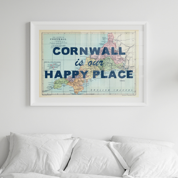 Framed custom map print of Cornwall with 'Cornwall is our happy place' text above a bed.