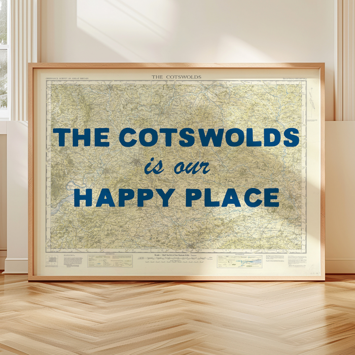 Cotswolds map print - Framed map with 'The Cotswolds is our happy place' text on a wooden floor.