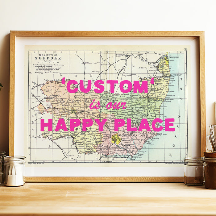 Custom map print - Framed map with 'Custom is our Happy Place' text on a wooden surface