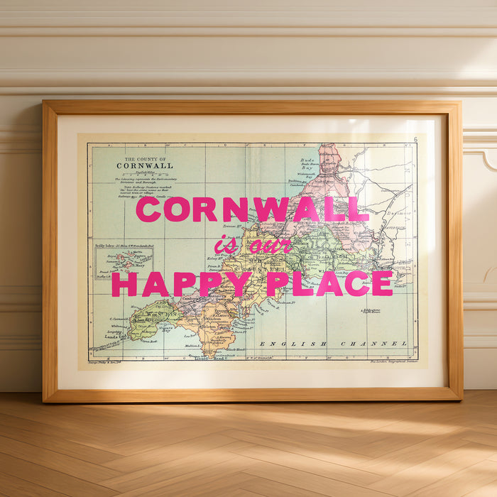 Framed custom map print of Cornwall with 'Cornwall is our happy place' text on a wooden floor.