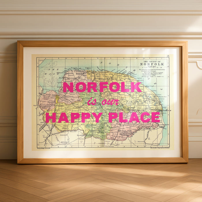 Framed custom map print of Norfolk with 'norfolk is our happy place' text on a wall.
