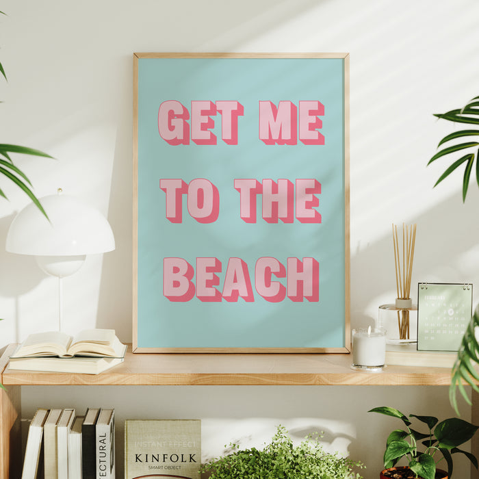 Framed poster with 'GET ME TO THE BEACH' text on a shelf with decor items.