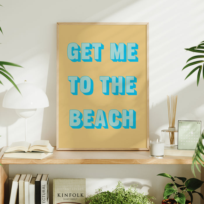Framed coastal artwork with 'GET ME TO THE BEACH' text on a shelf with decor items.