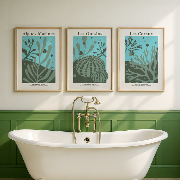 Bathroom with a freestanding bathtub, green tiled wall, and a set of three framed coral artwork of marine life.