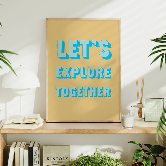 Framed poster with 'Let's Explore Together' text on a shelf with books and plants.