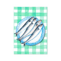 Hand-painted artwork of fish on a plate. Sardines on a blue plate, placed on a green gingham tablecloth.