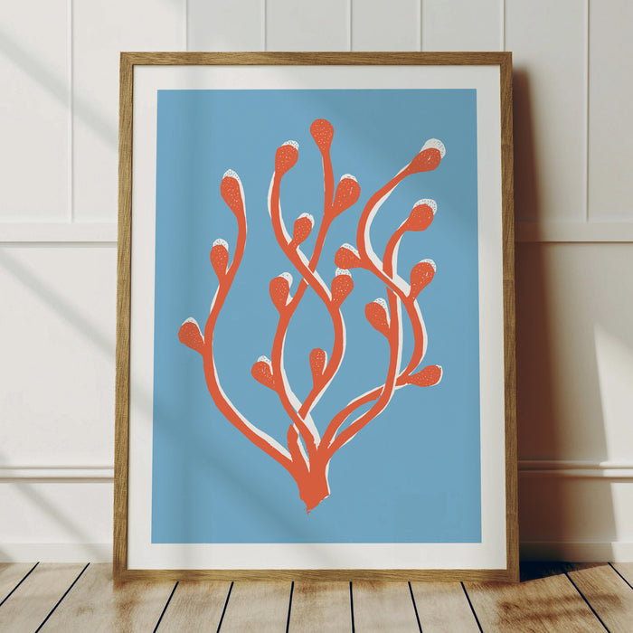 A lino cut style art print featuring abstract orange seaweed against a blue background, framed.