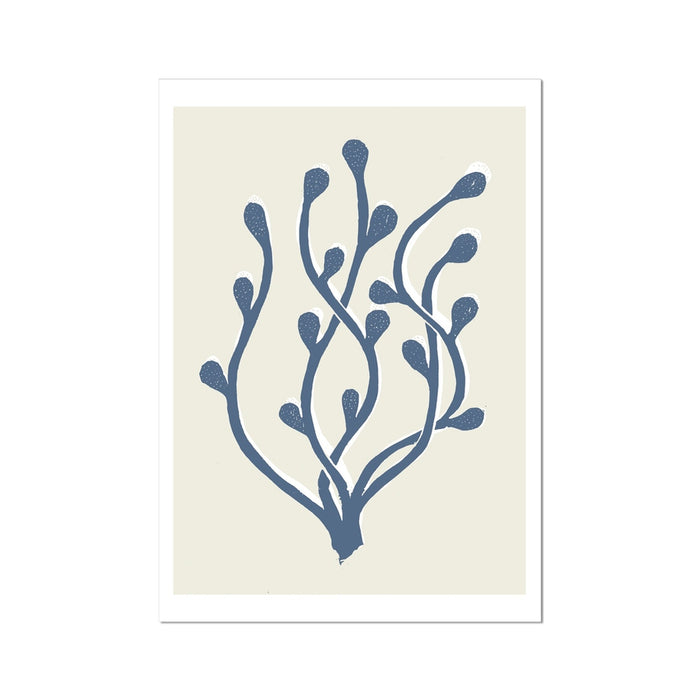 A framed art print of abstract indigo blue seaweed against a white background, displayed in a simple black frame.