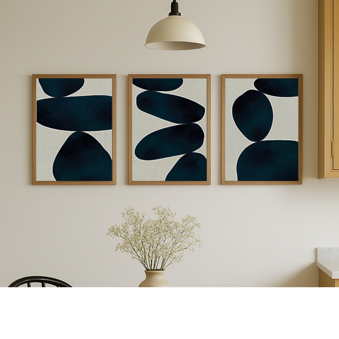 Set of Three abstract art pieces with zen blue shapes on a wall above a vase with flowers.
