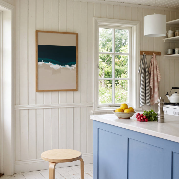 Kitchen interior with blue cabinets, white countertop, and framed abstract artwork on the wall.