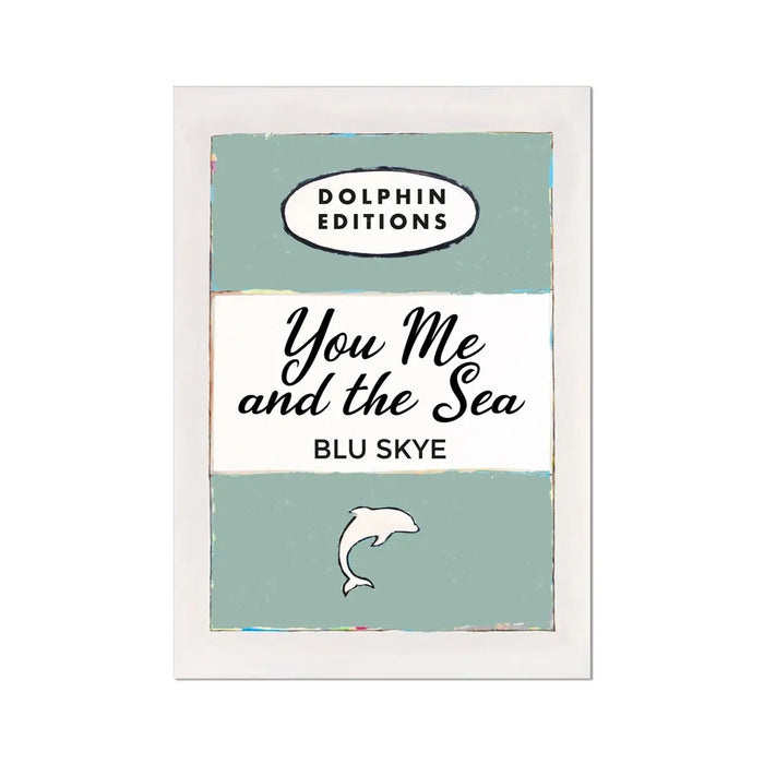 A framed art print featuring a vintage book cover art with the title 'You Me and the Sea' by Blu Skye, with a green background and a small illustration of a dolphin at the bottom.